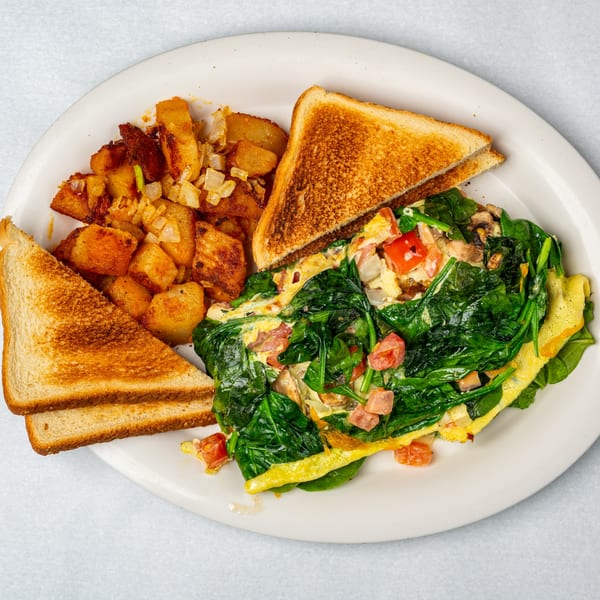 Oakcrest Family Restaurant's omelet with spinach, tomatoes, and mushrooms, served with home fries and toast.