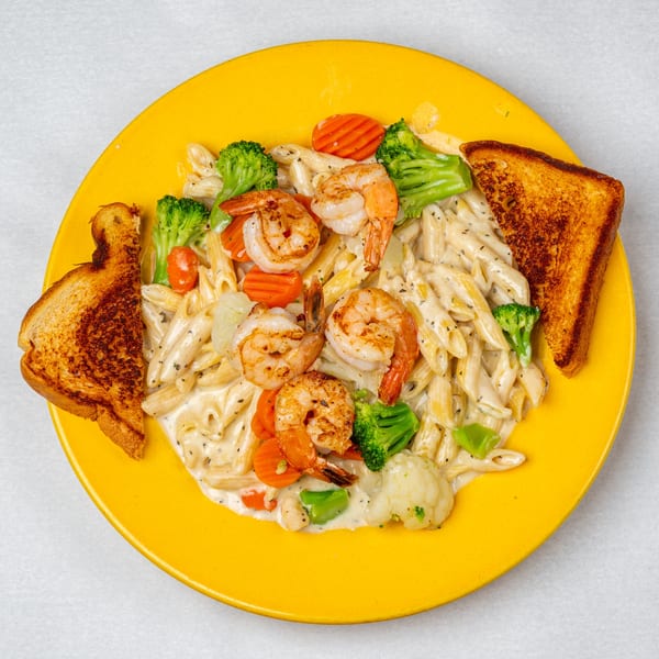 Oakcrest Family Restaurant's creamy penne pasta with shrimp, broccoli, carrots, and toasted bread.