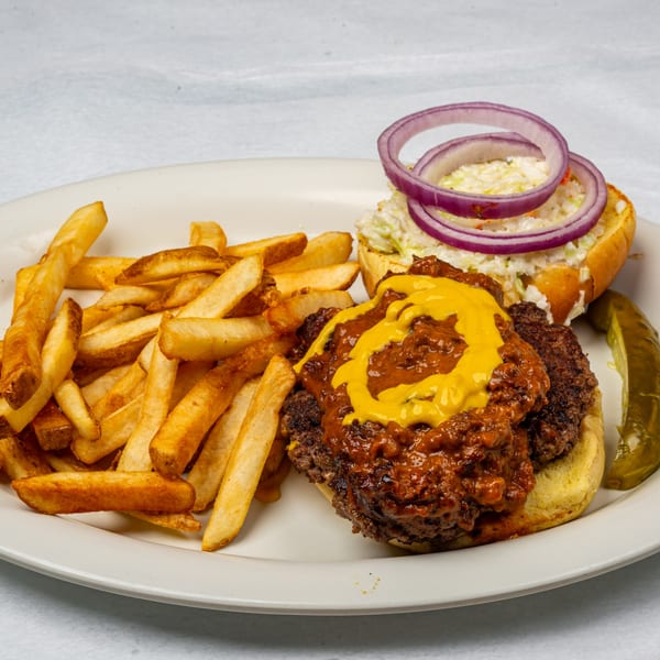 Oakcrest Family Restaurant's chili cheeseburger with mustard, coleslaw, red onion, fries, and a pickle.